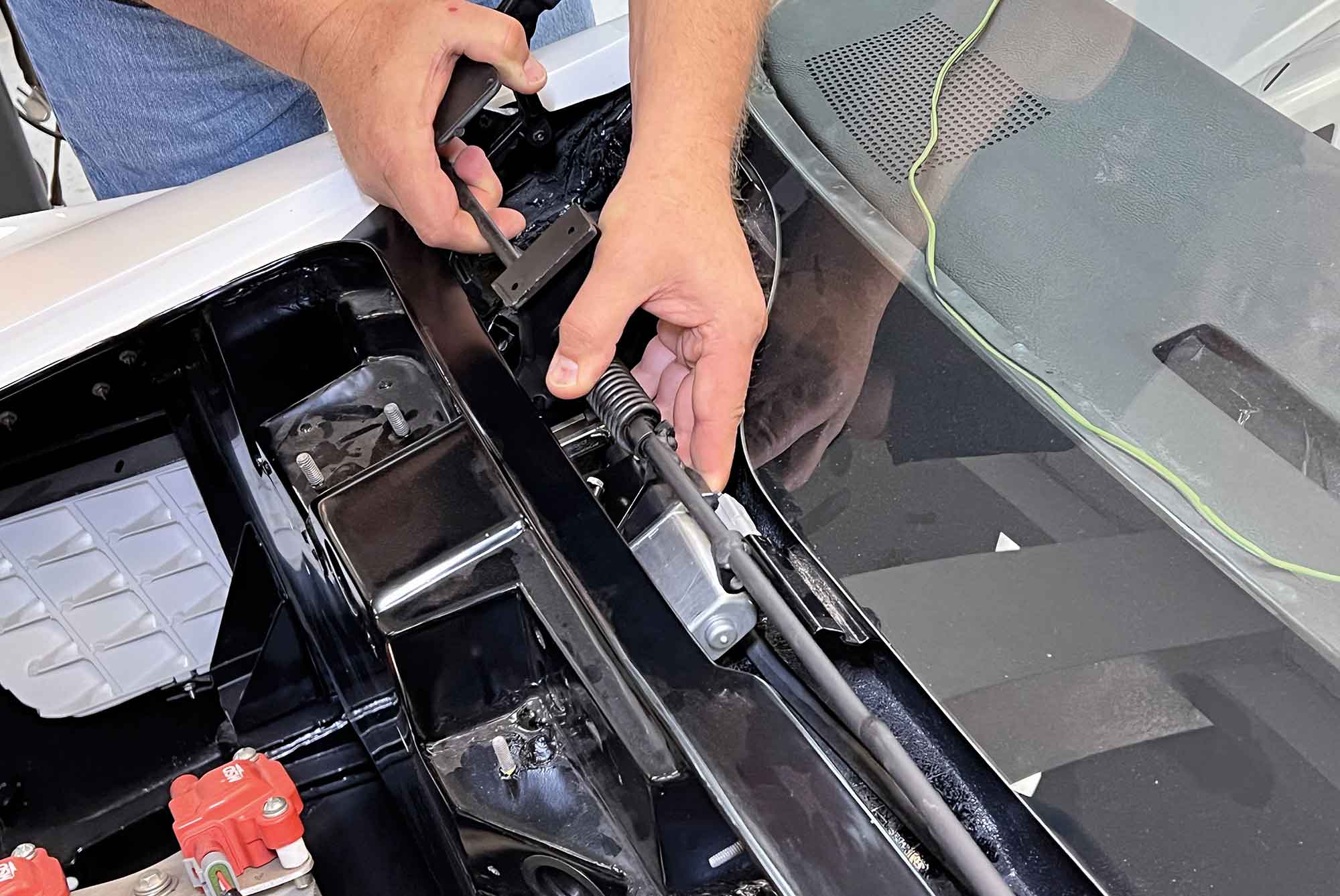 Close-up of hands adjusting the wiper door linkage assembly.