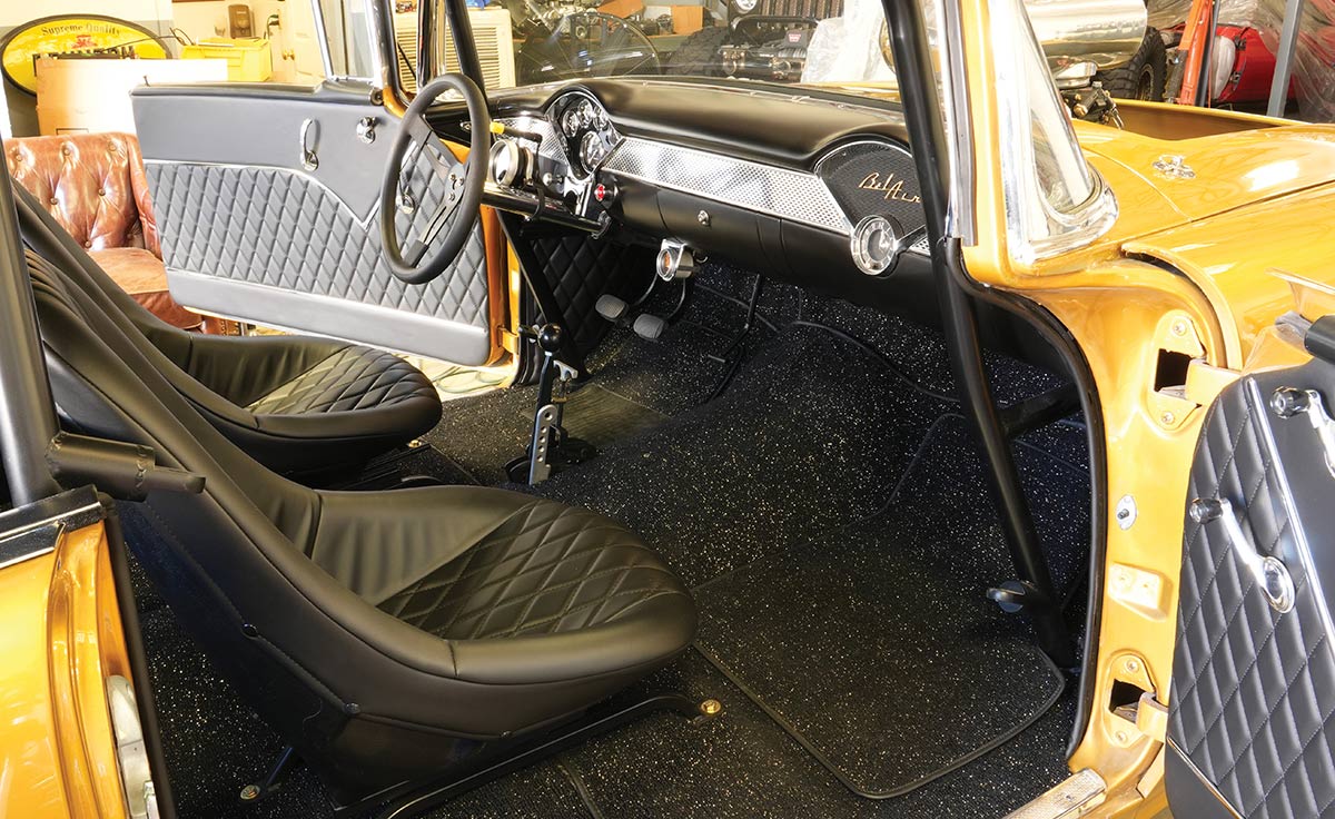 Interior of a 1955 Chevy Bel Air gasser with racing seats and roll cage.