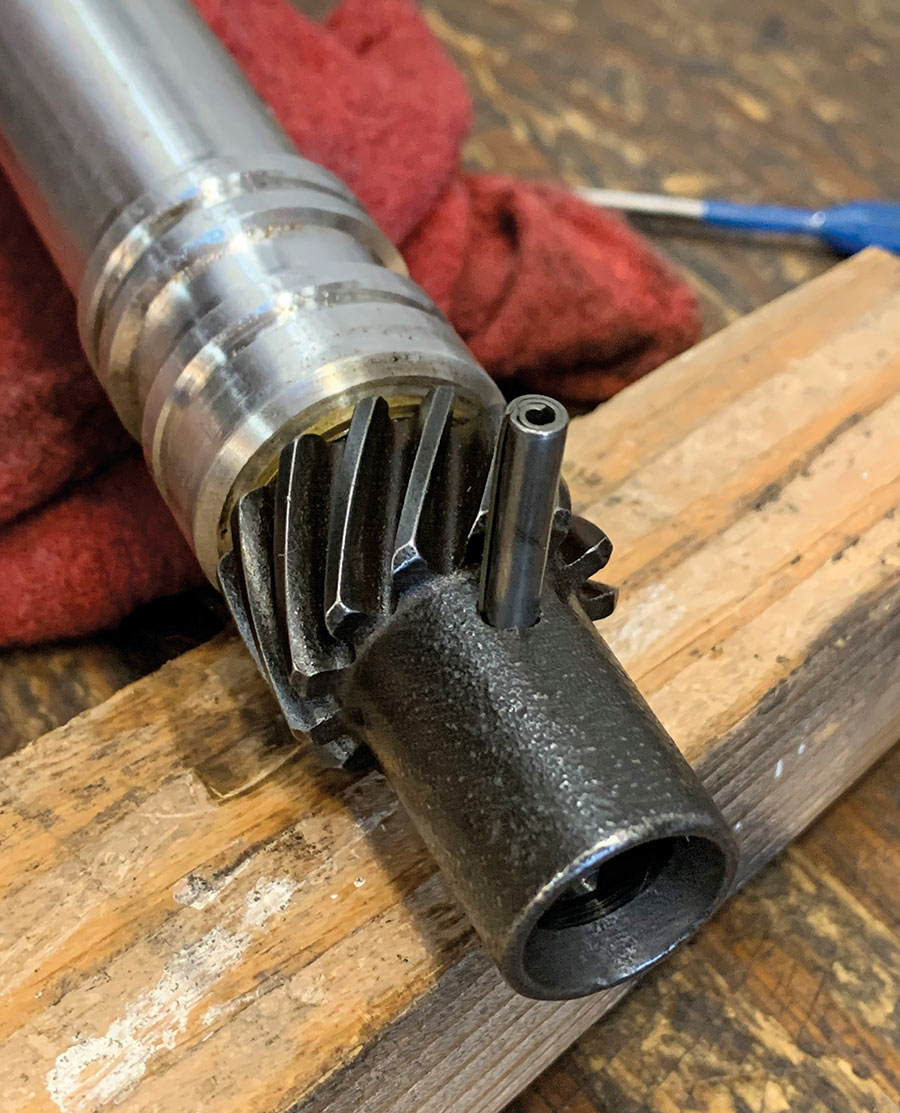 Installing a roll pin in a melanized gear.