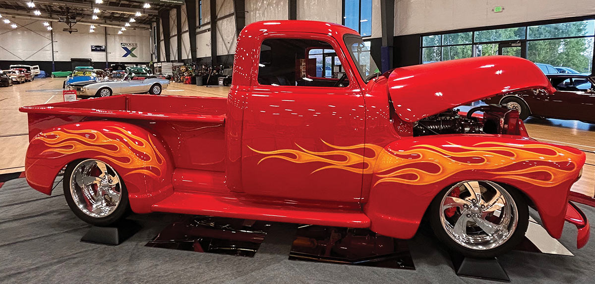 Red 1951 Chevy three-window pickup with flame graphics