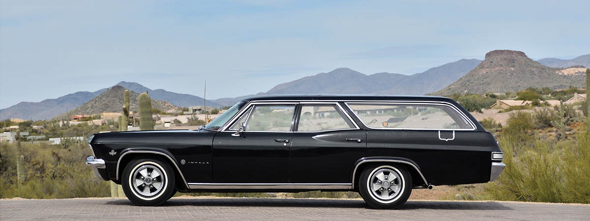 Side view of black 1965 Chevy Impala wagon.
