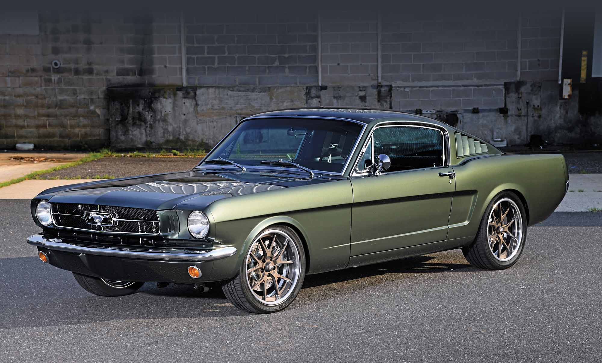 Front three-quarter view of a dark green 1965 Mustang.